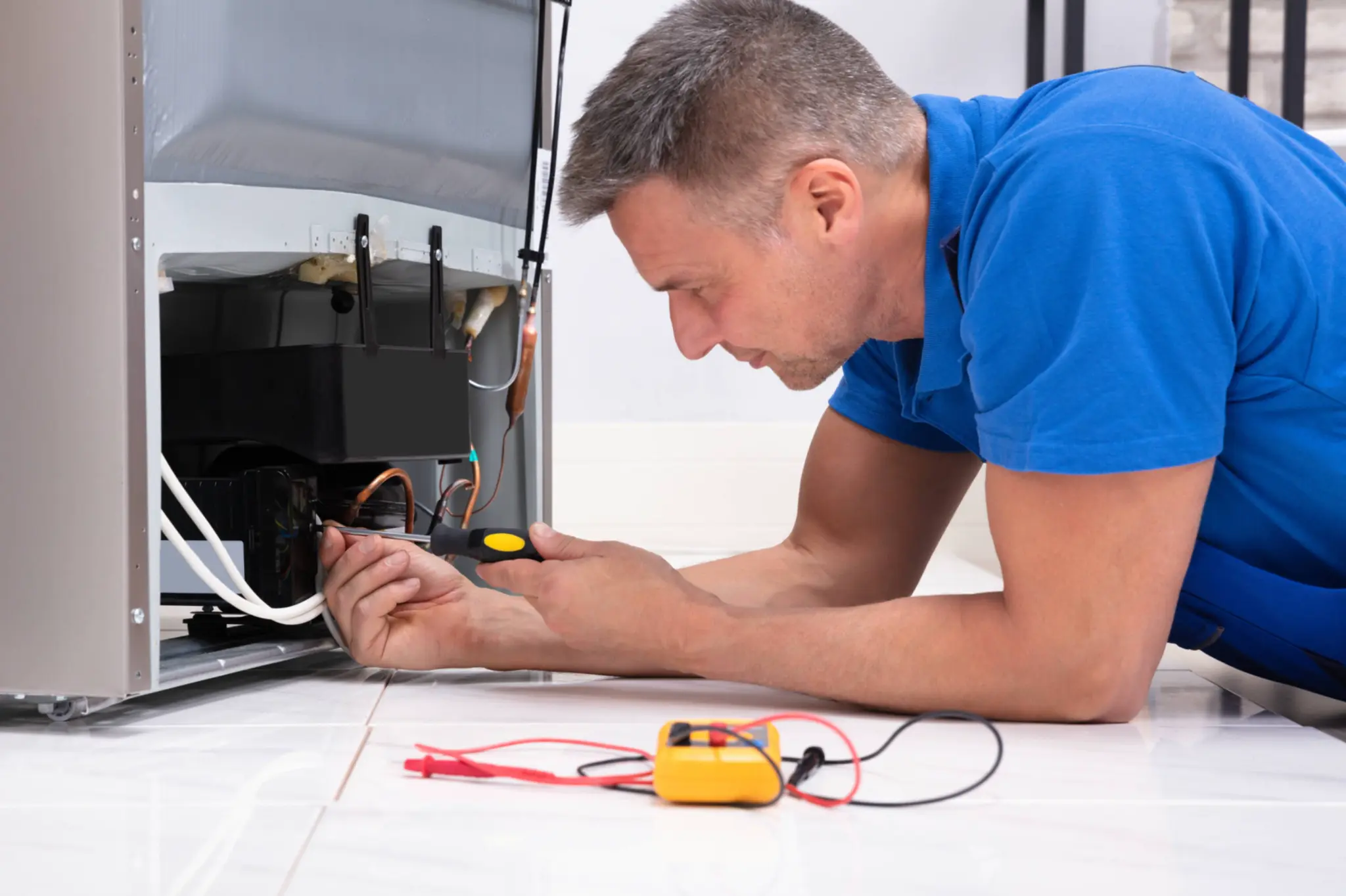 Technician testing the lower components of an ice machine