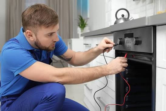 Technician using electrical test leads on a residential oven