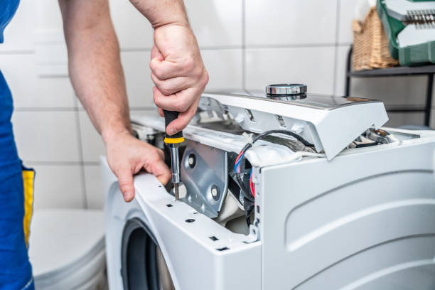 Close-up of a technician opening a washer control assembly