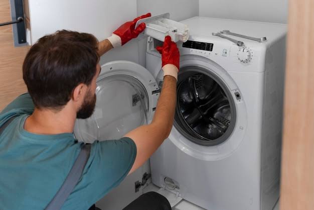 Technician lifting the control panel of a front-load washing machine